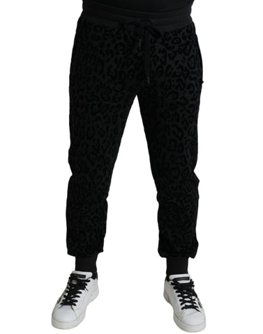 Black leopard print cotton slim fit jogger pants by Dolce & Gabbana with elastic waistband and tapered cuffs.