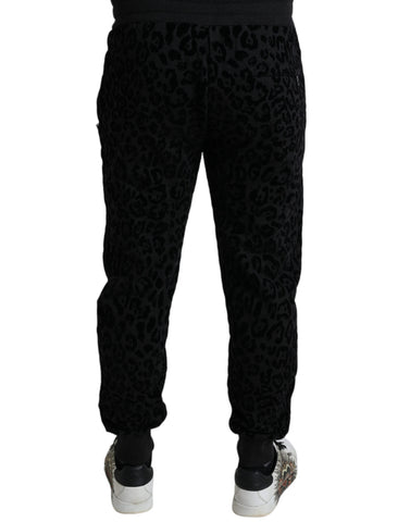 Black leopard print cotton slim fit jogger pants by Dolce & Gabbana, featuring a tapered design and elastic waistband.