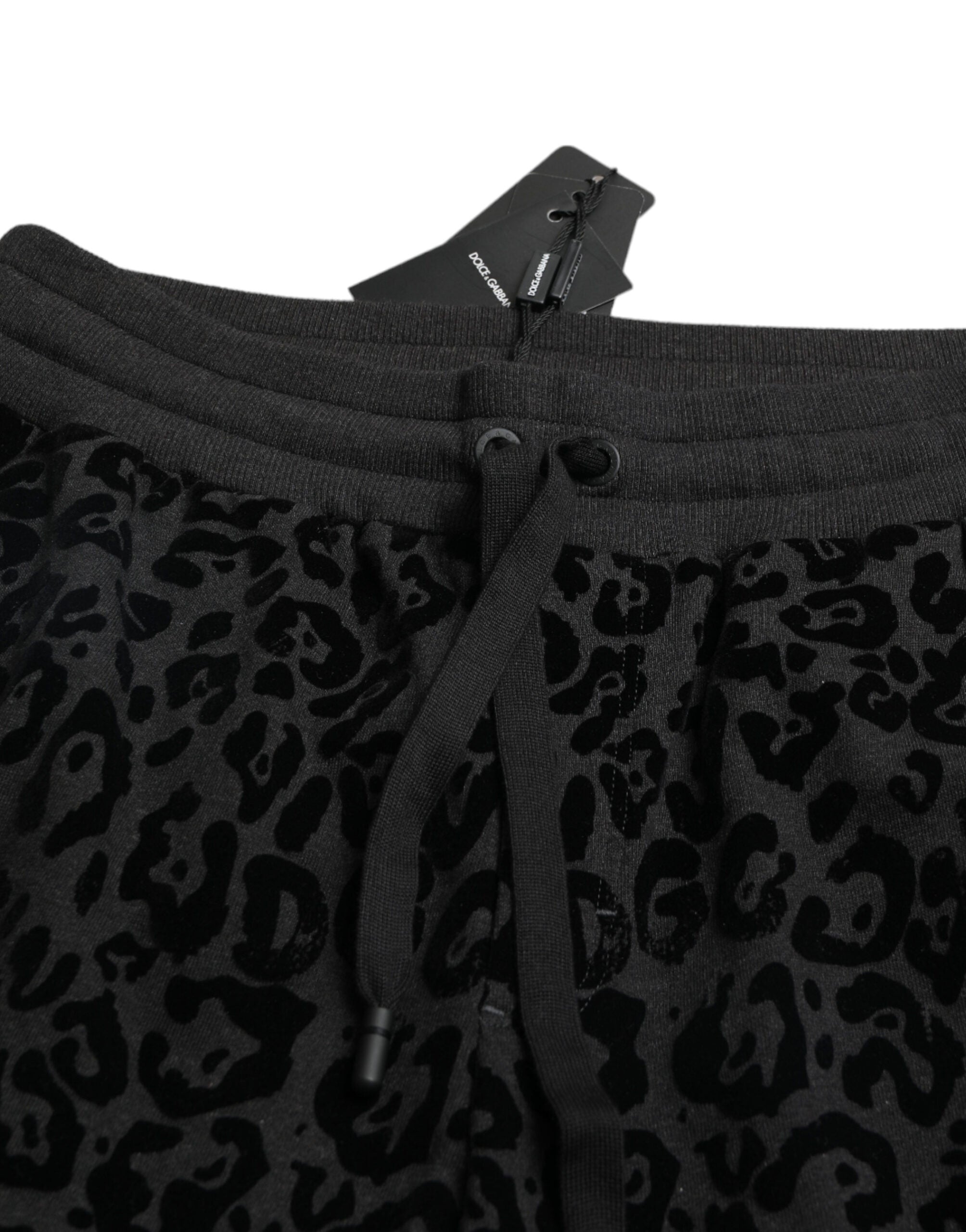 Black leopard print cotton slim fit jogger pants by Dolce & Gabbana, featuring elastic waistband and tapered leg fit.