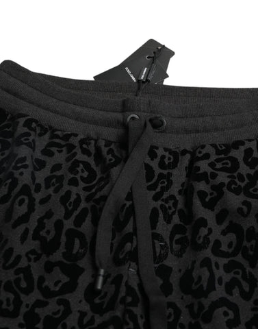 Black leopard print cotton slim fit jogger pants by Dolce & Gabbana, featuring elastic waistband and tapered leg fit.