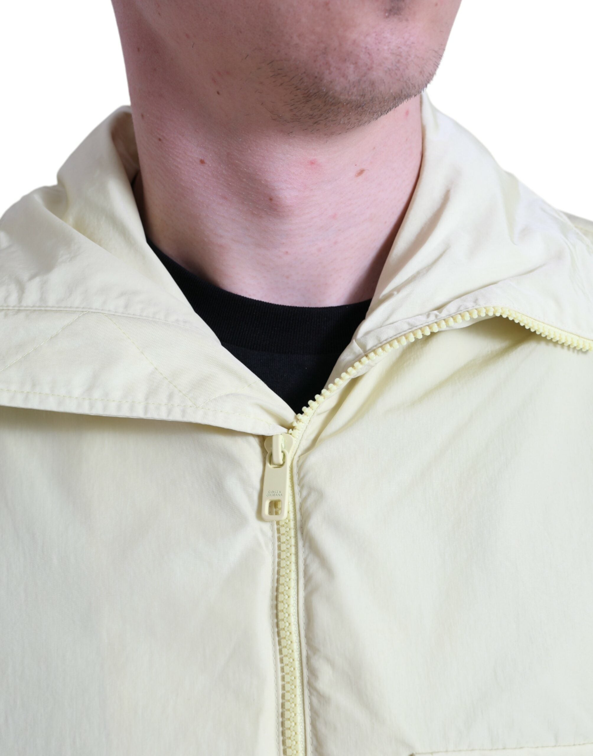 Yellow nylon collared full zip parka jacket by Dolce & Gabbana displayed on a hanger.
