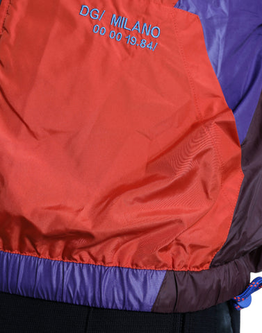 Multicolor Dolce & Gabbana windbreaker jacket with vibrant color blocks and lightweight material, shown on a hanger.