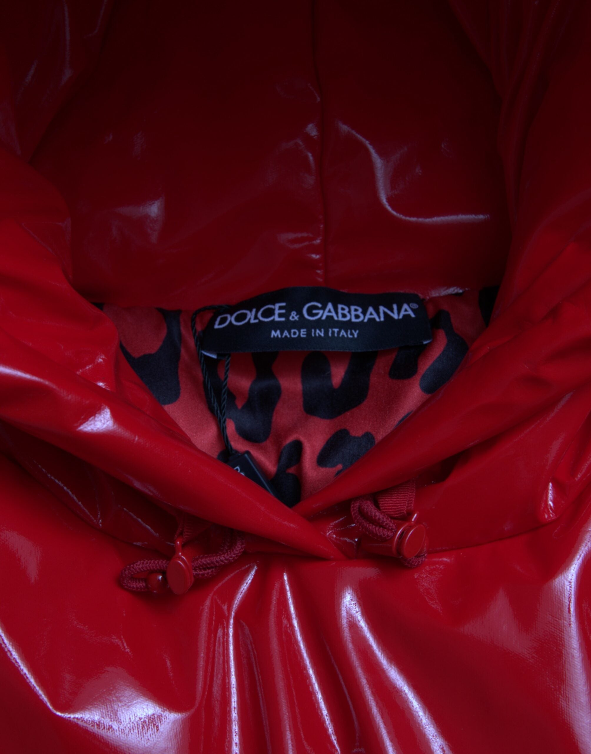 Shiny red hooded cropped short coat jacket by Dolce & Gabbana, featuring a sleek, glossy finish and stylish hood design.