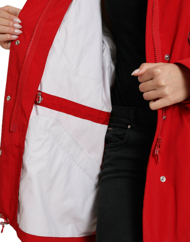 Red polyester hooded rain coat jacket with button closure from Dolce & Gabbana, shown hanging on a wooden hanger.