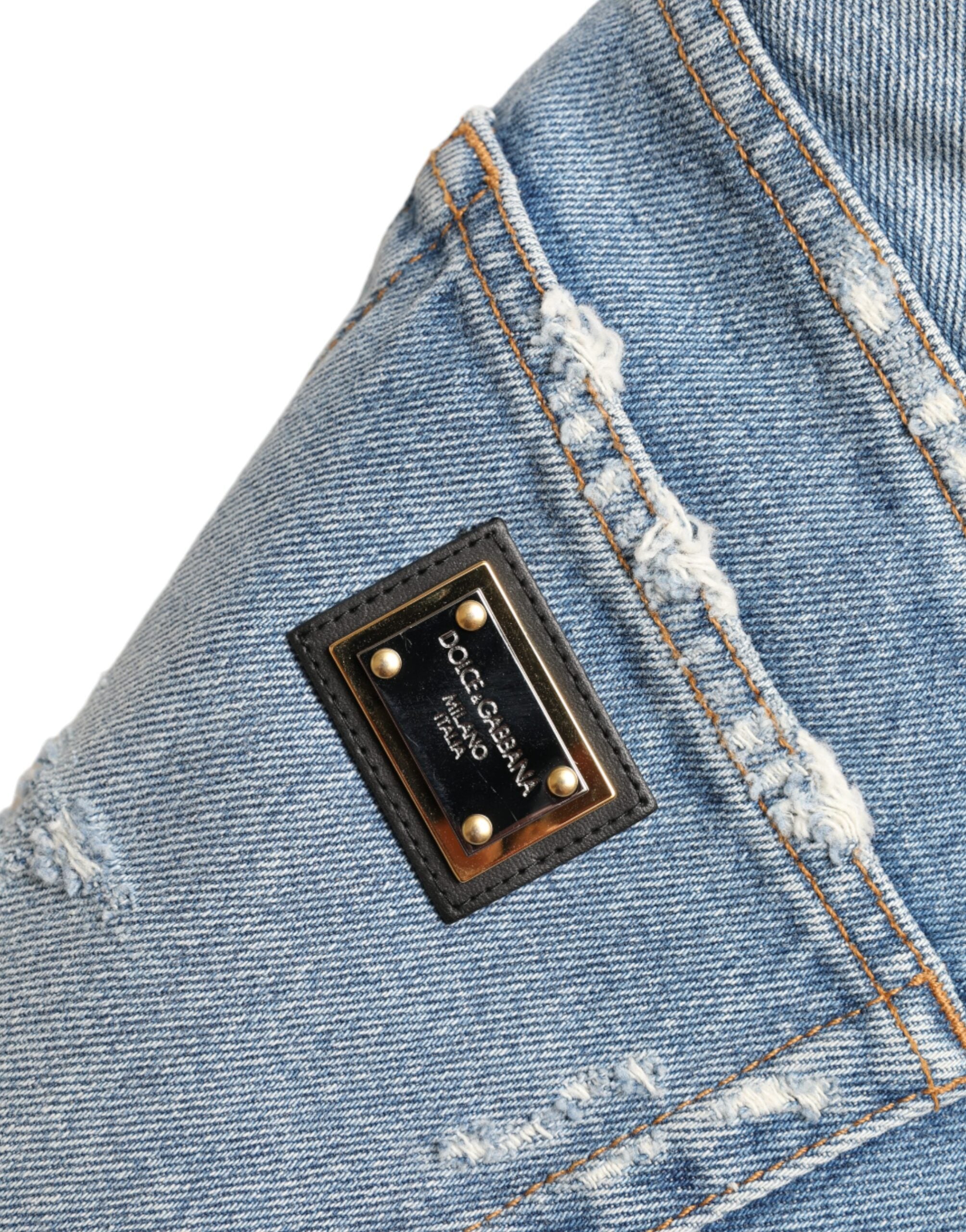 Blue tattered embellished Bermuda shorts by Dolce & Gabbana with distressed details and decorative embellishments.