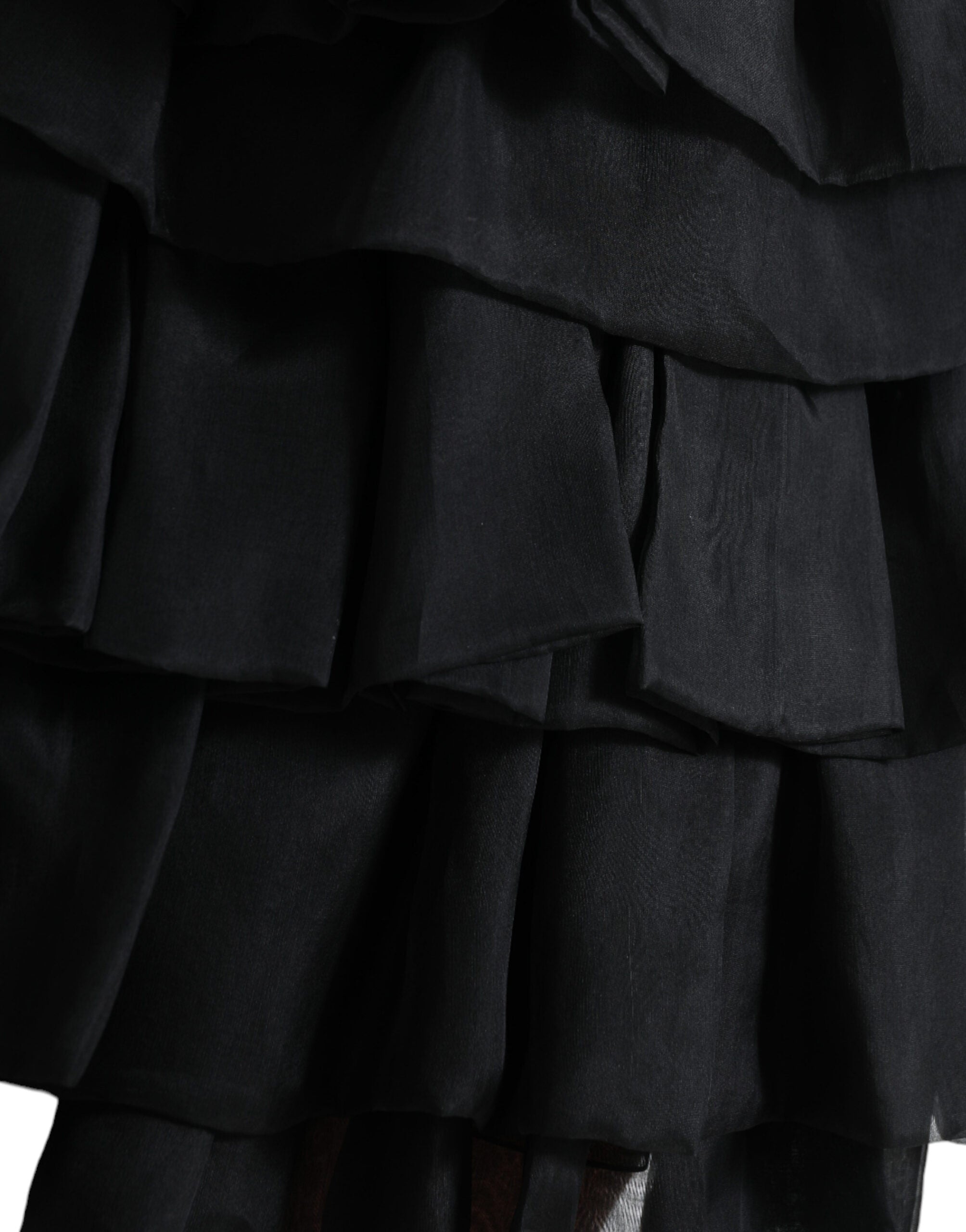 Black tiered A-line silk mini skirt with high waist from Dolce & Gabbana, shown on a model with a flowy, elegant design.