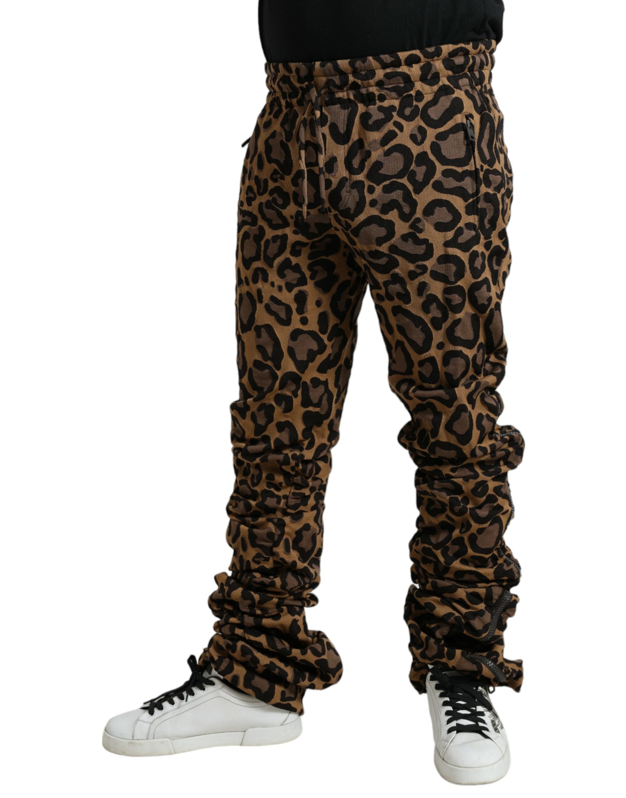 Brown leopard jacquard jogger pants by Dolce & Gabbana with elastic waistband and tapered fit on model.