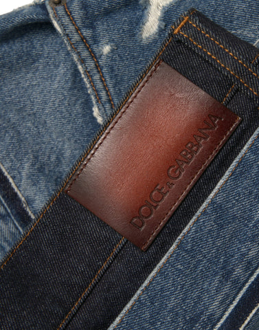 Blue tattered cotton denim jeans for men by Dolce & Gabbana, featuring distressed details and a classic fit.