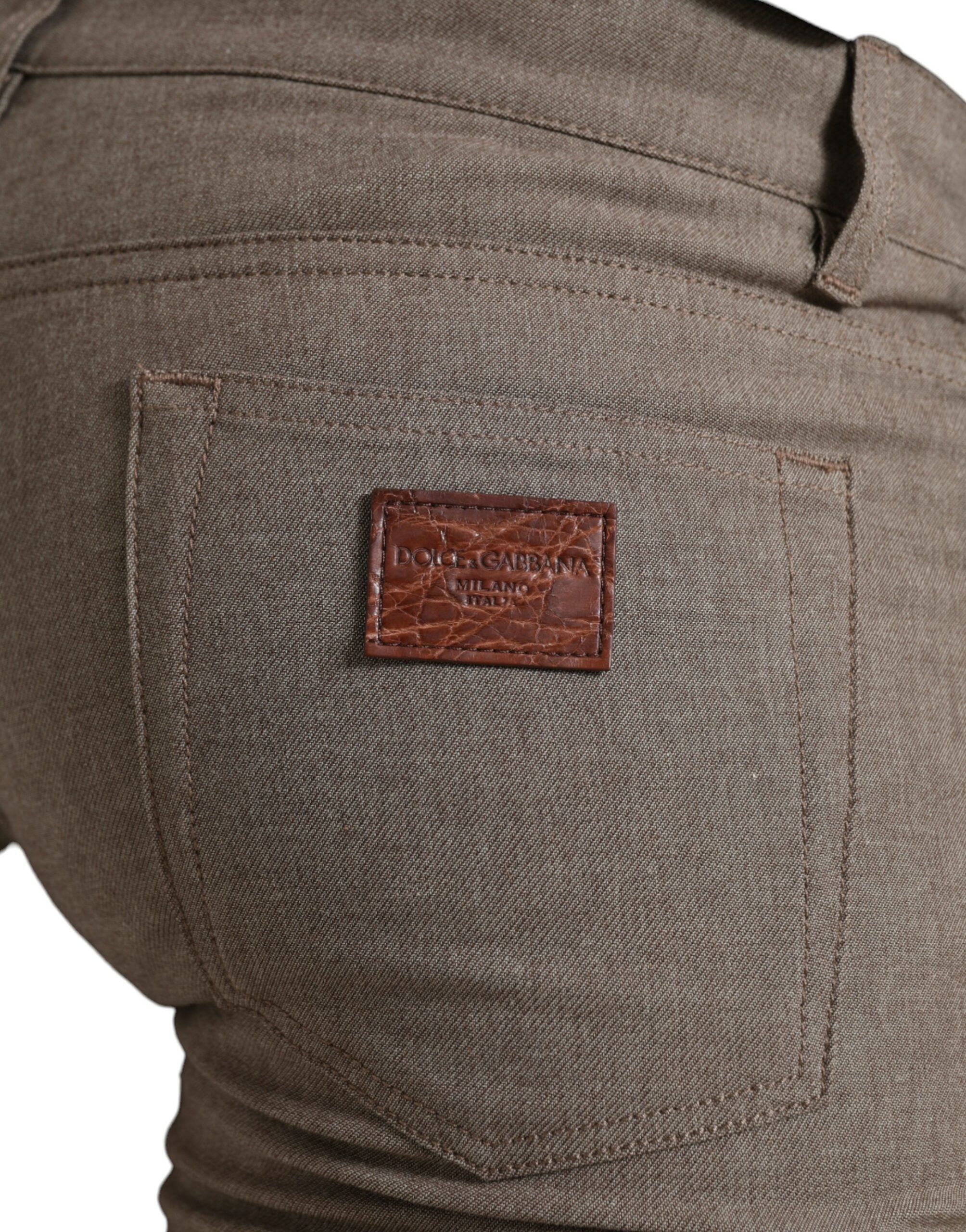 Brown cotton stretch skinny men's pants by Dolce & Gabbana, showing close-up of fitted waistband and fabric texture.