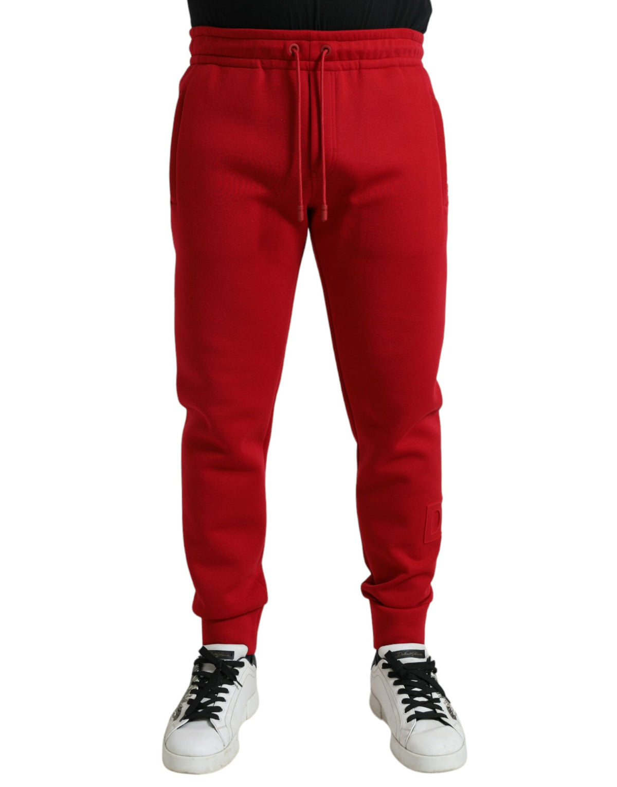 Red cotton blend skinny jogger pants by Dolce & Gabbana displayed on a hanger with details of the fabric and fit visible.