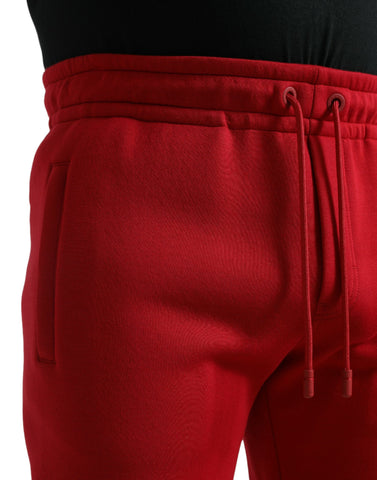 Red cotton blend skinny jogger pants by Dolce & Gabbana, shown with elastic waistband and tapered fit.