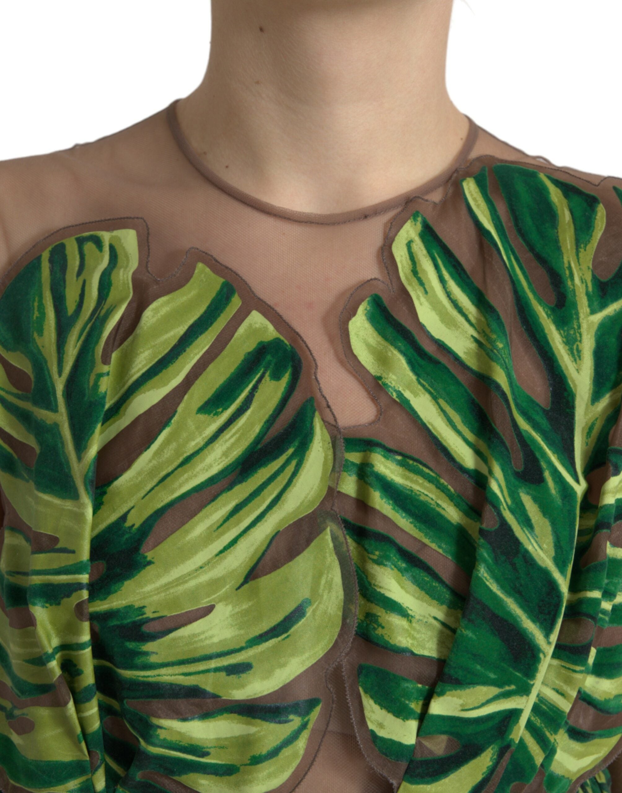 Green banana leaf sleeveless maxi dress by Dolce & Gabbana, flowing fabric with tropical leaf pattern, full-length design.