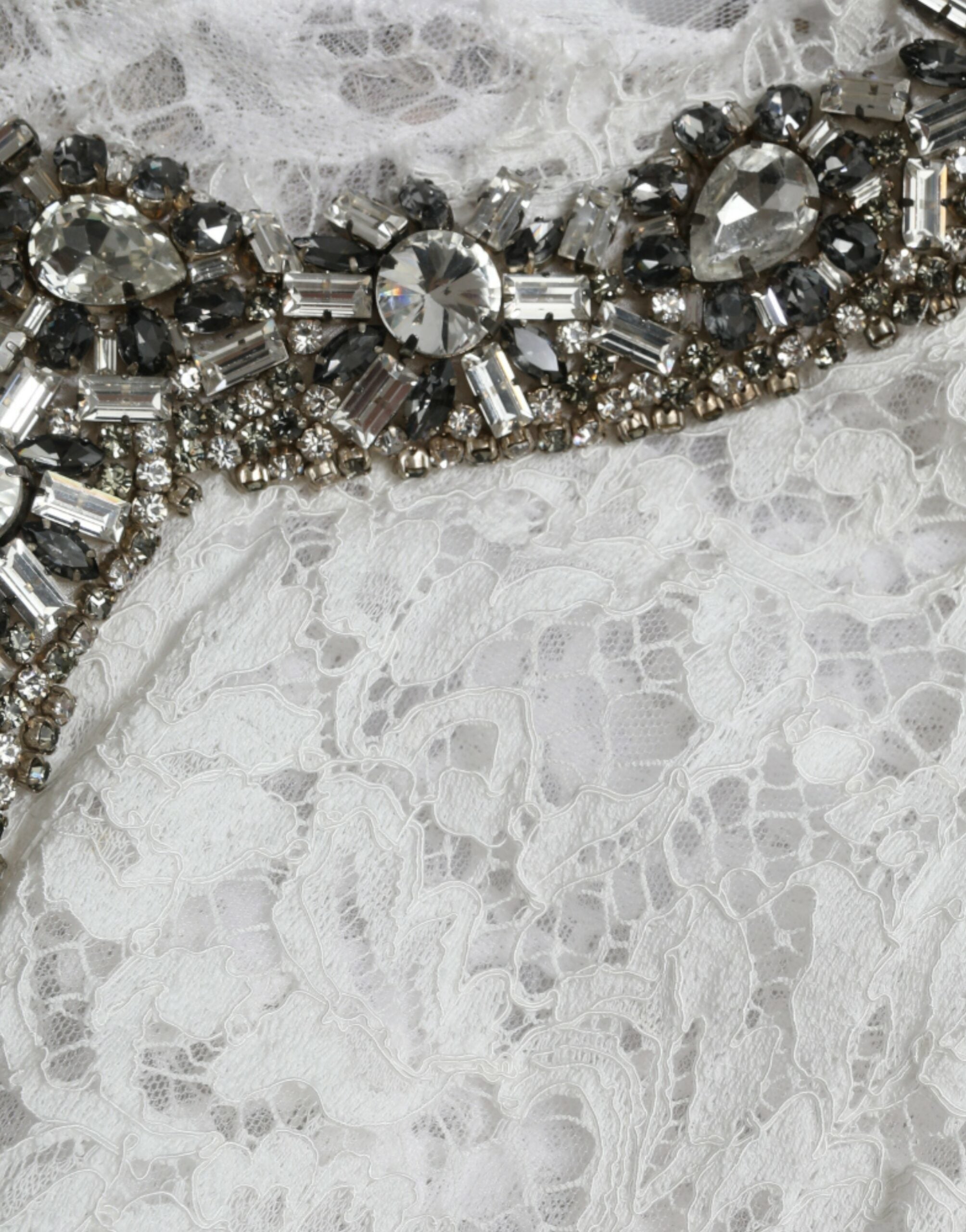 White lace shift dress with crystal embellishments by Dolce & Gabbana, featuring elegant details and a sleek silhouette.