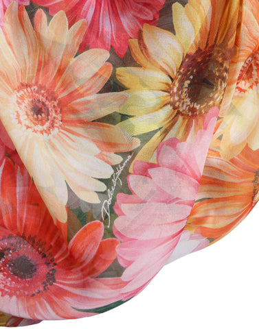 Multicolor sunflower print silk midi dress by Dolce & Gabbana displayed on a mannequin. Bright floral pattern with flowing fabric.