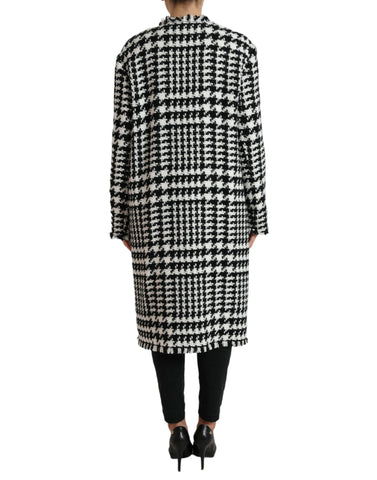 Dolce & Gabbana black and white houndstooth trench coat jacket displayed on a hanger, showcasing classic design and tailored fit.