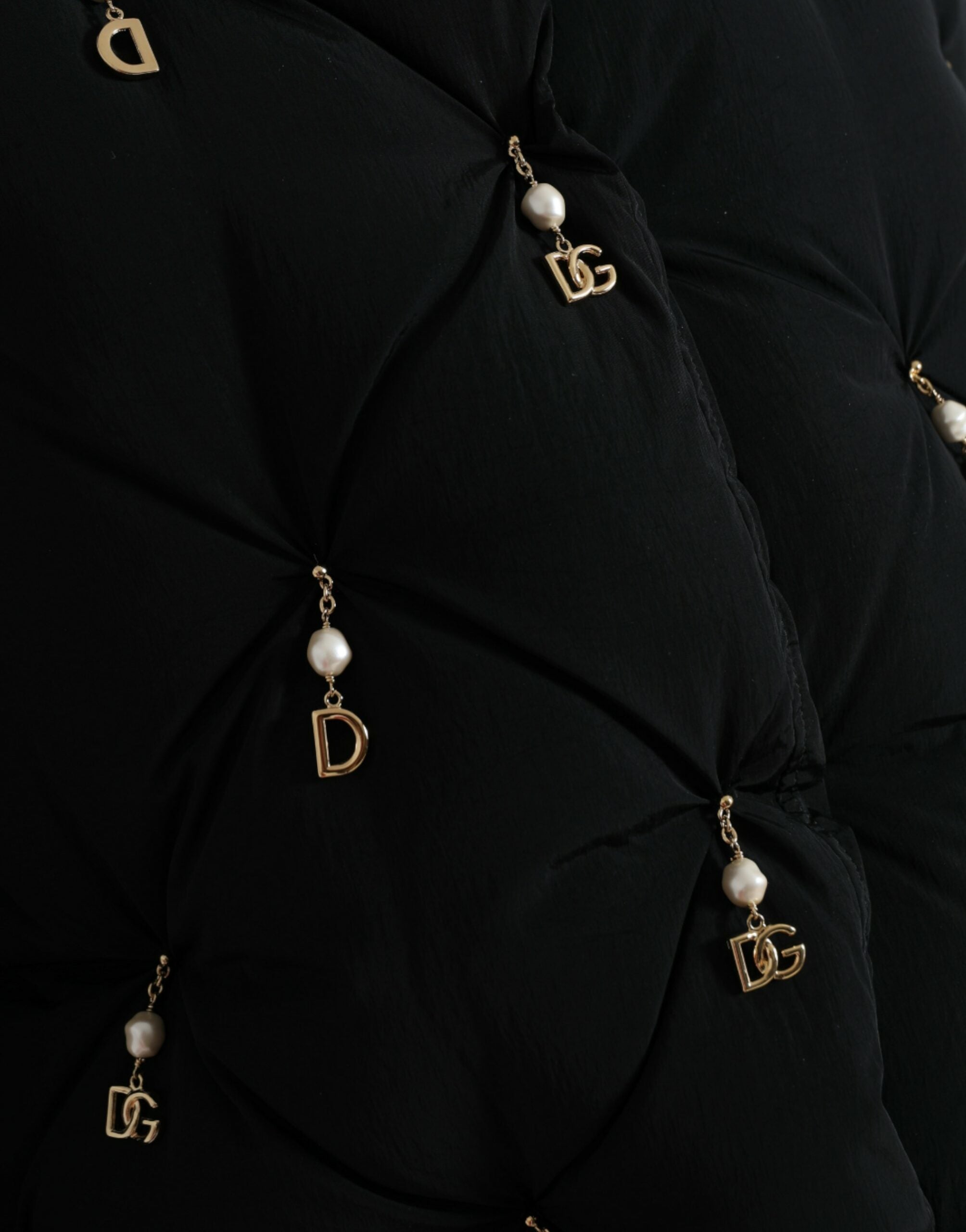 Black quilted shell bomber jacket with embellishments by Dolce & Gabbana, featuring a fitted design and decorative details.