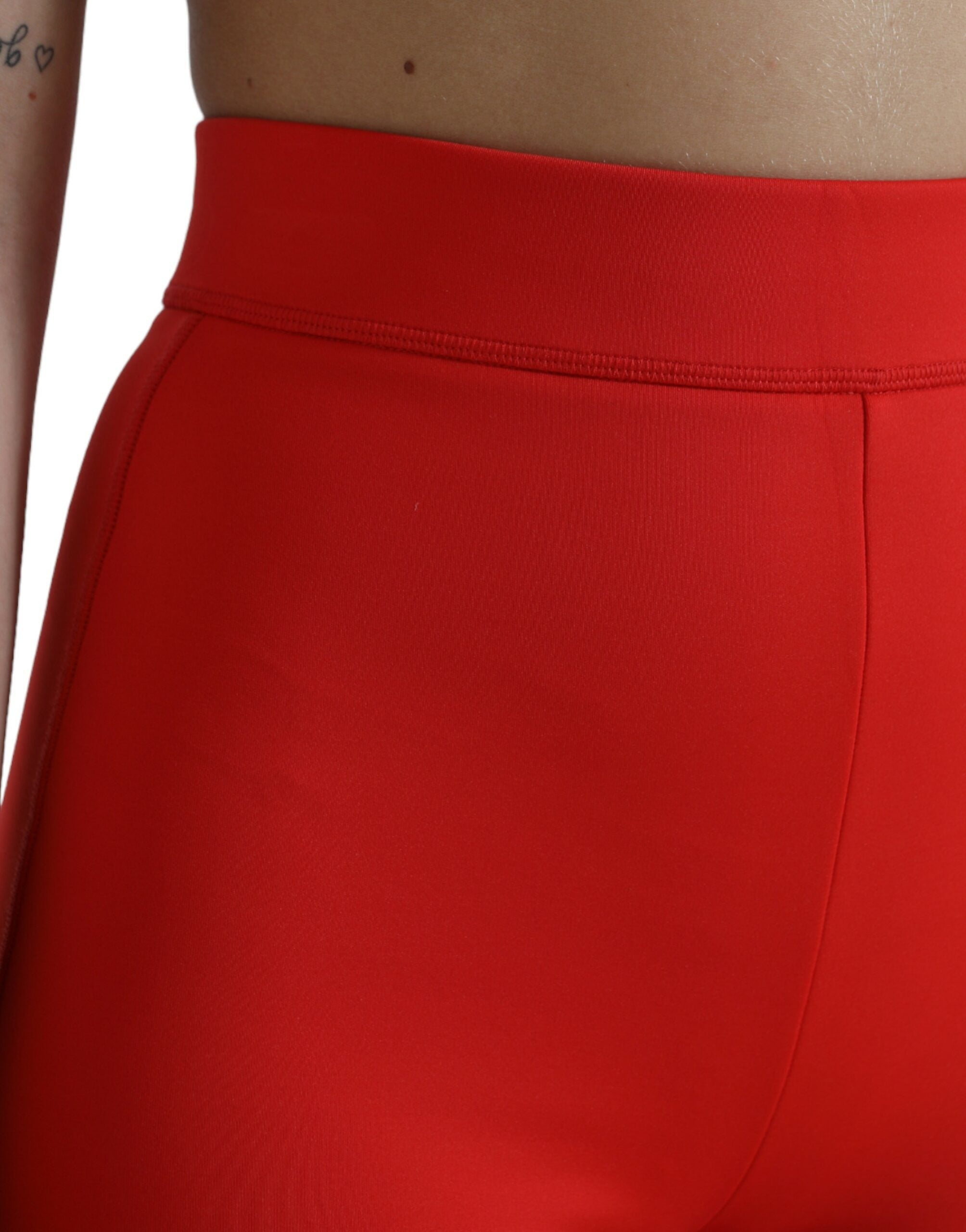 Red nylon stretch slim leggings pants by Dolce & Gabbana, close-up of fitted, smooth fabric and sleek design.