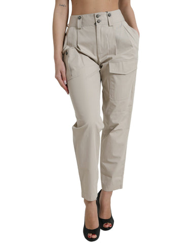 Beige cotton high waist tapered pants by Dolce & Gabbana displayed on a hanger with a neutral background.