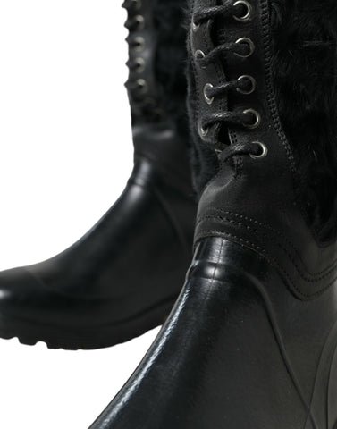 Black rubber shearling rain boots with lace-up design by Dolce & Gabbana, featuring sturdy soles and cozy shearling lining.