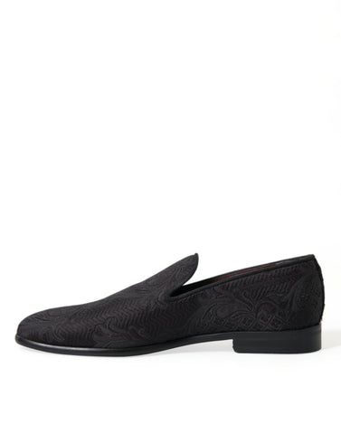 Black brocade slip-on men's dress loafers by Dolce & Gabbana, featuring elegant detailing and a sleek, stylish design.