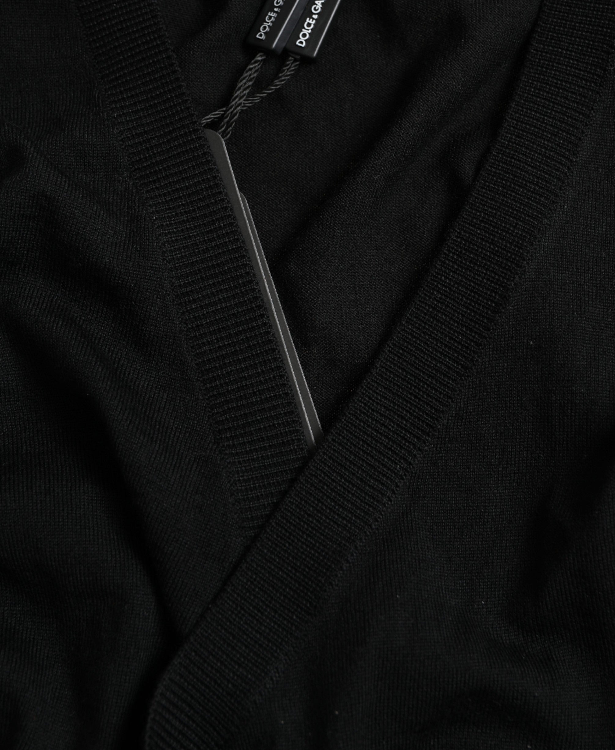 Black wool V-neck crossed cardigan sweater by Dolce & Gabbana displayed on a hanger.