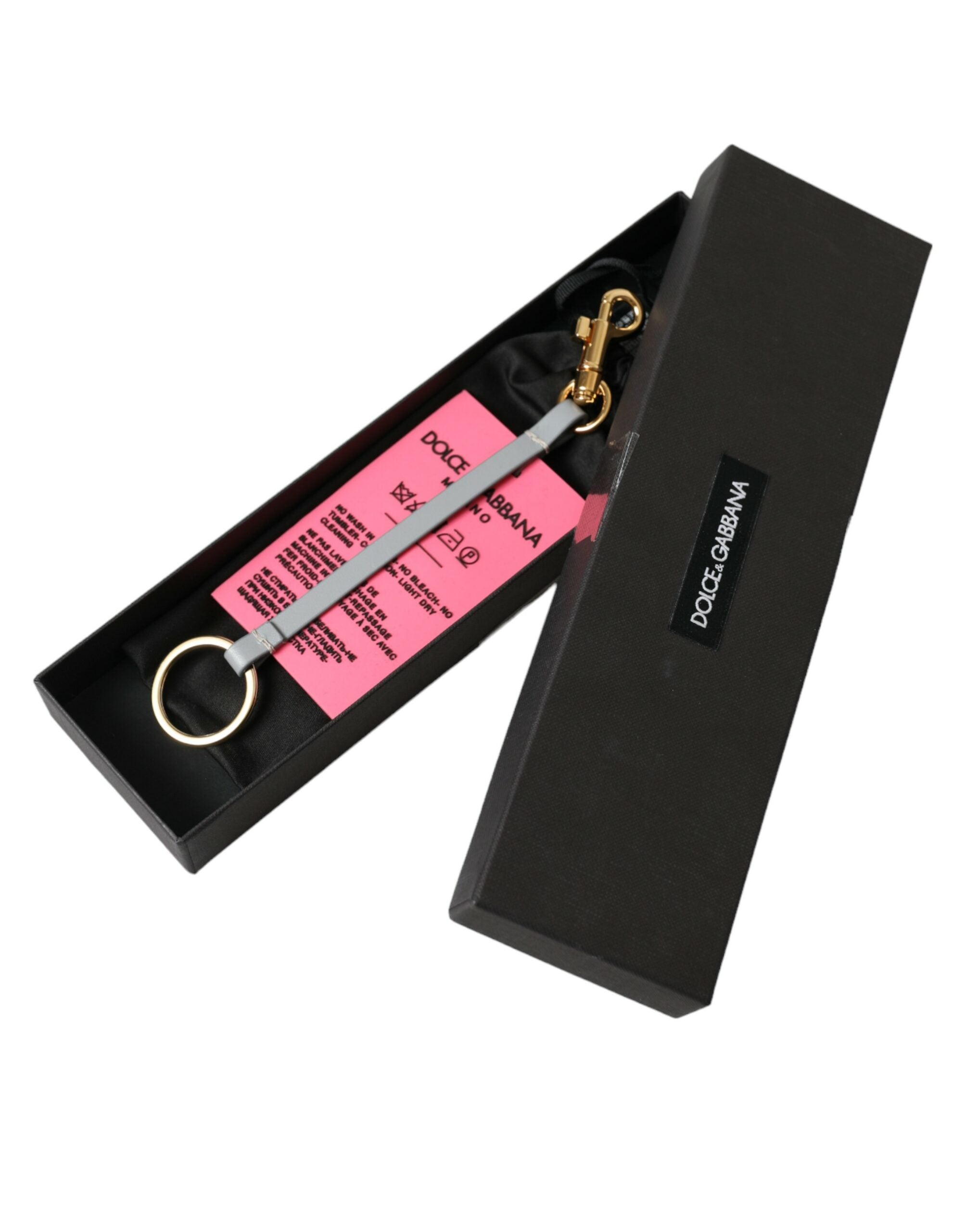 Pink silicone Dolce & Gabbana keychain with gold brass DG logo. Stylish accessory with a vibrant, modern design.