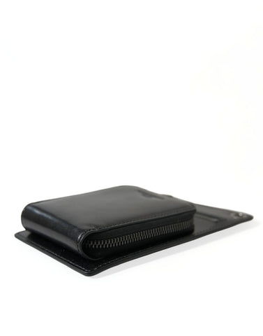 Black leather Dolce & Gabbana wallet with zip closure, logo detail, crossbody strap, and phone slot.