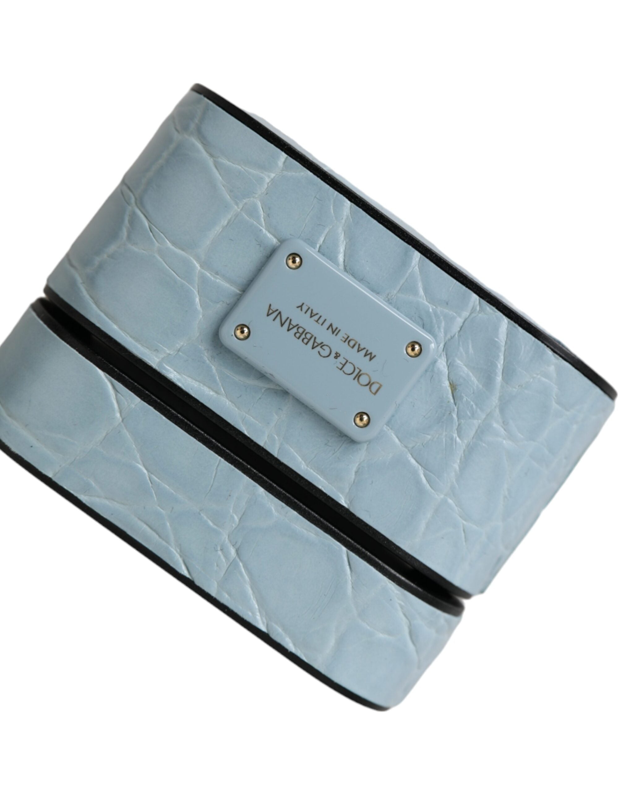 Light blue leather AirPods case with metal logo plaque by Dolce & Gabbana, showing smooth leather surface and sleek design.