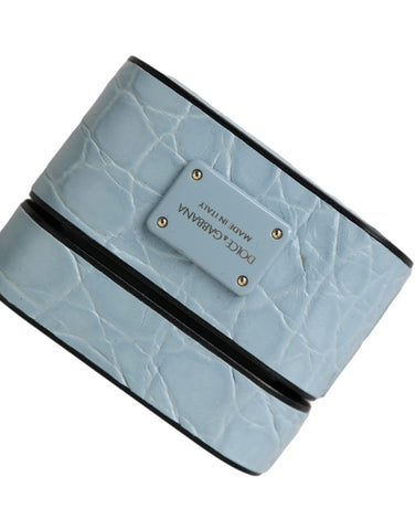 Light blue leather AirPods case with metal logo plaque by Dolce & Gabbana, showing smooth leather surface and sleek design.