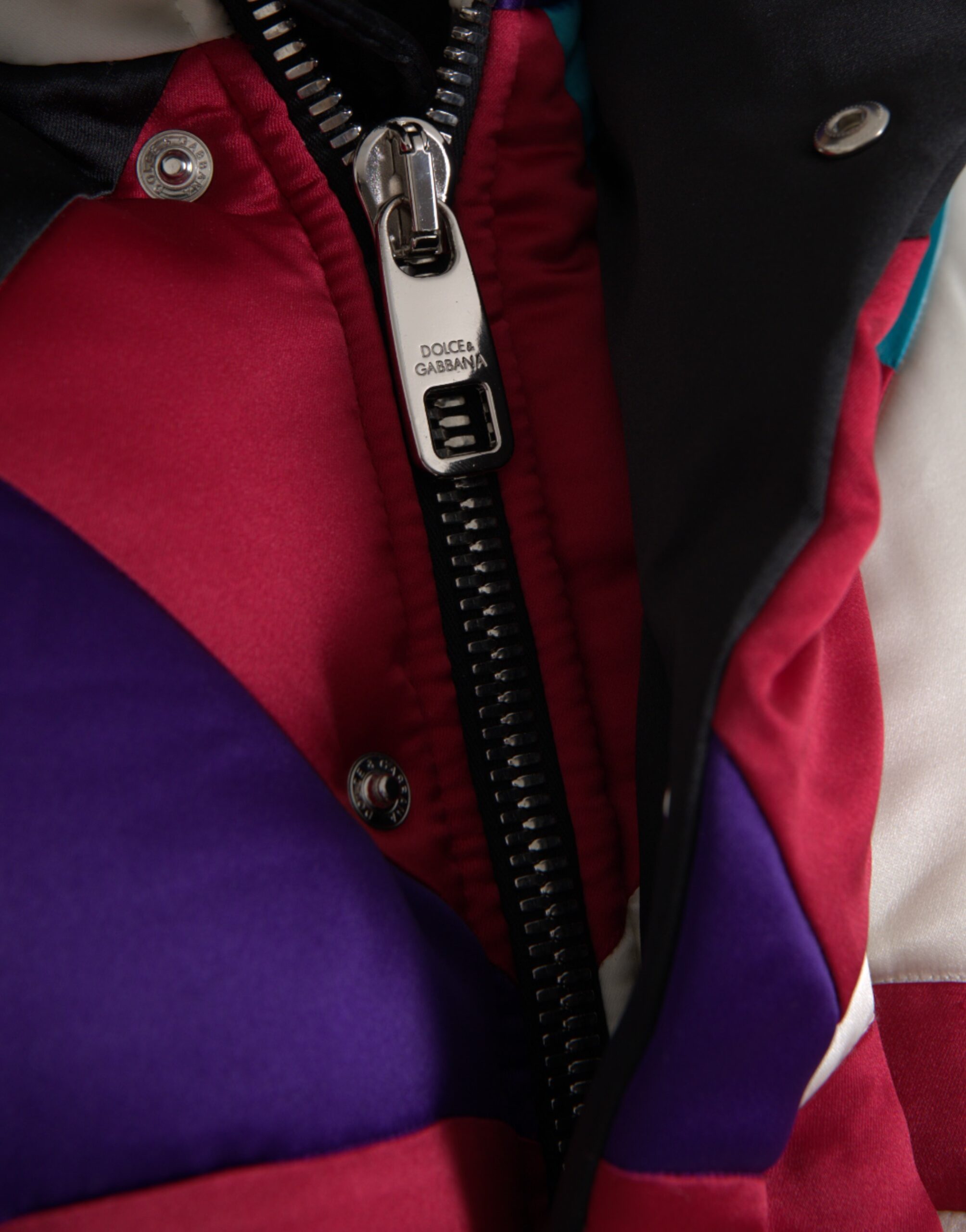 Multicolor logo Dolce & Gabbana puffer windbreaker jacket with vibrant design and quilted texture, front zipper, and hood.