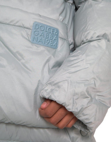 Light blue quilted hooded puffer jacket for men by Dolce & Gabbana, featuring a stylish quilted design and hood.