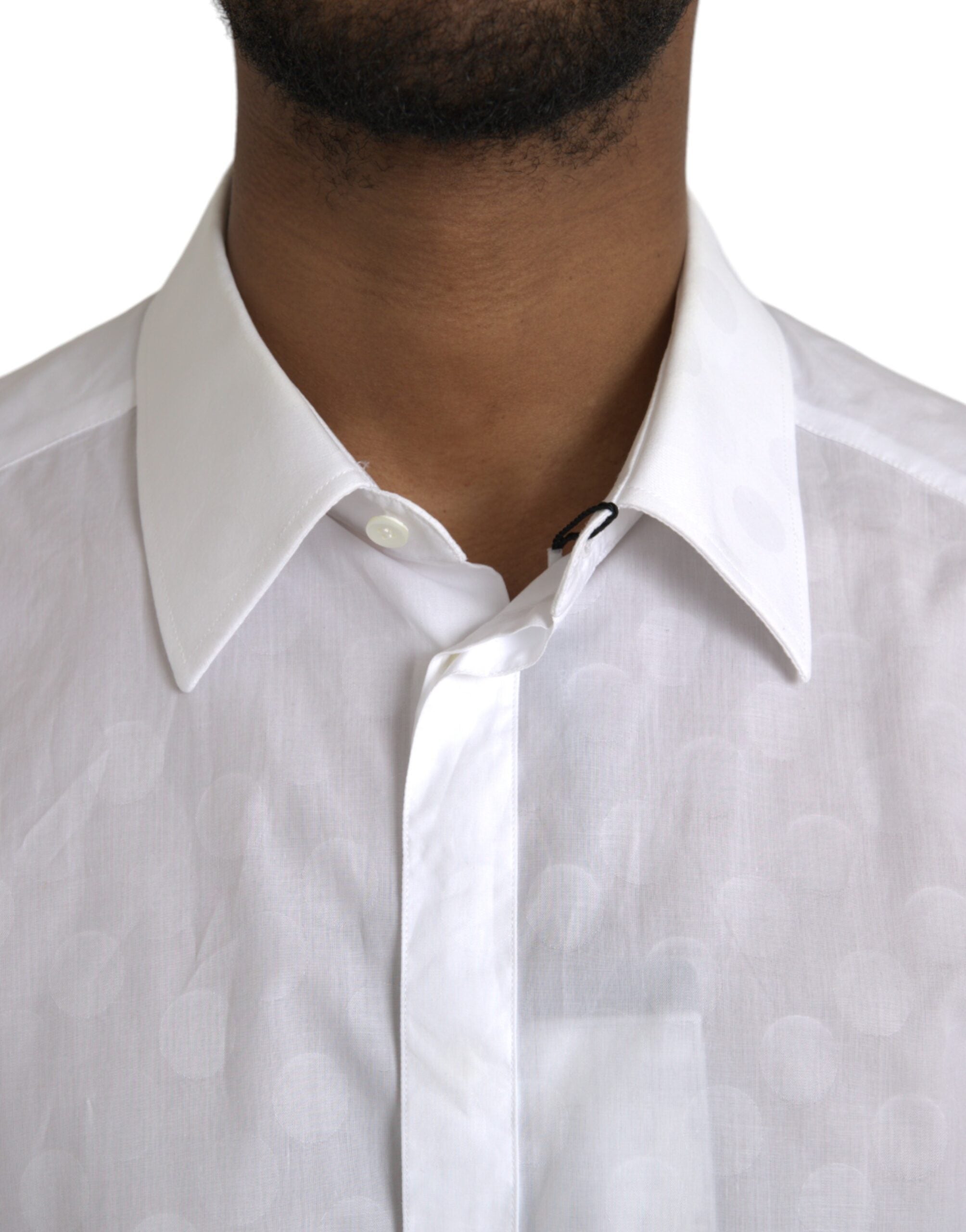 White cotton dress with black polka dots and gold accents, designed by Dolce & Gabbana, shown on a hanger against a neutral background.