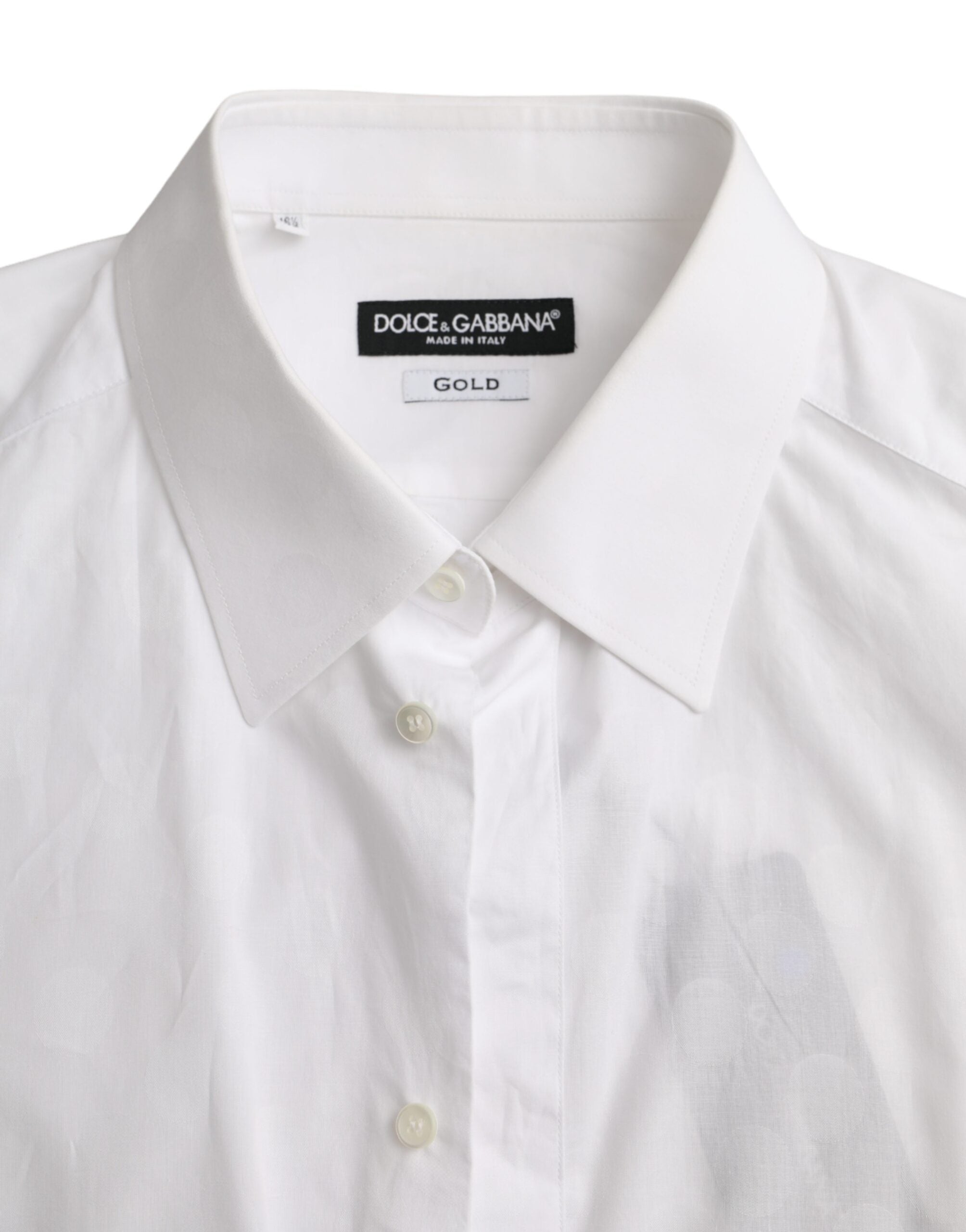 White cotton dress with black polka dots and gold accents, designed by Dolce & Gabbana, shown on a mannequin.