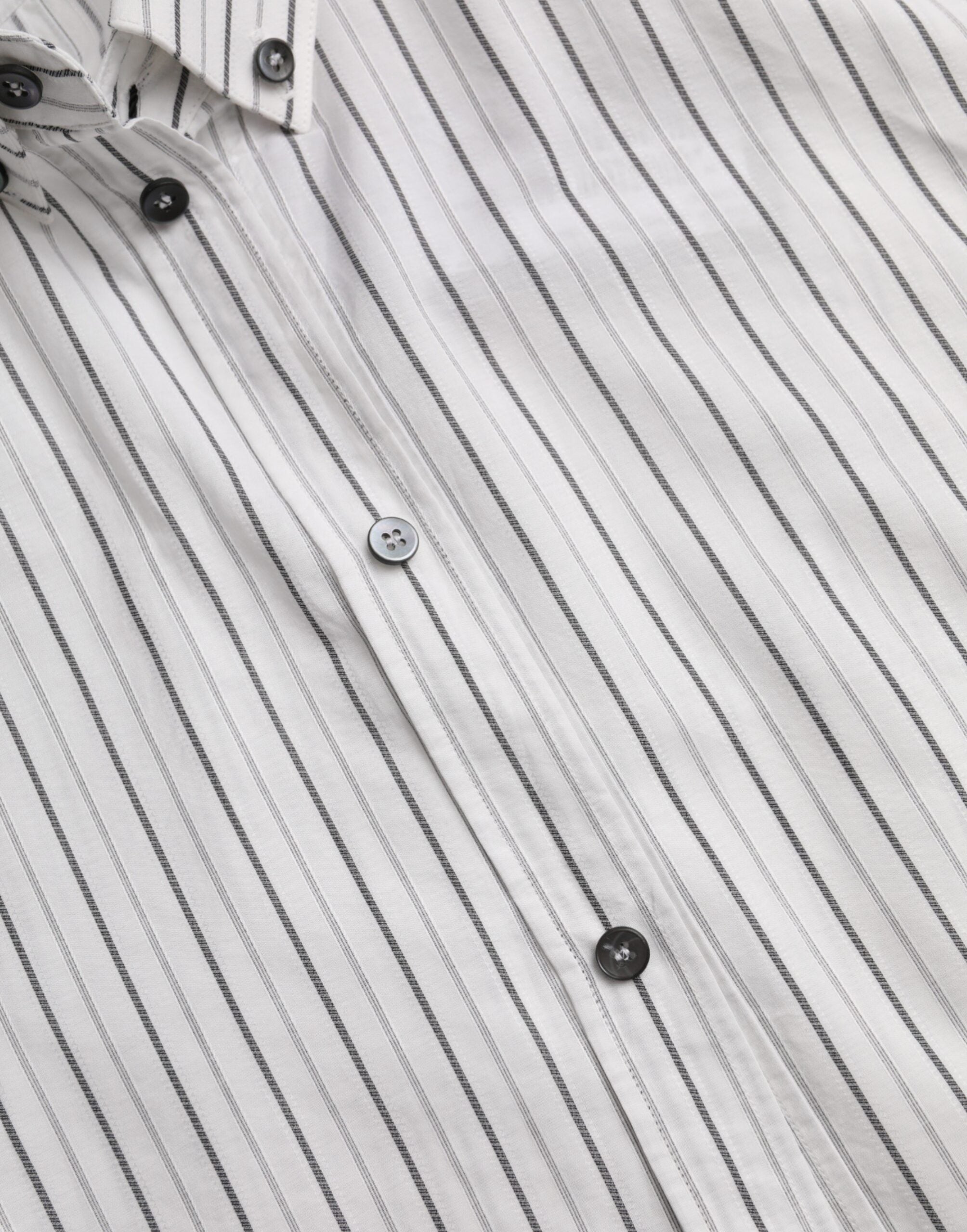 Black and white striped formal dress with gold shirt accents, designed by Dolce & Gabbana, shown on a model.