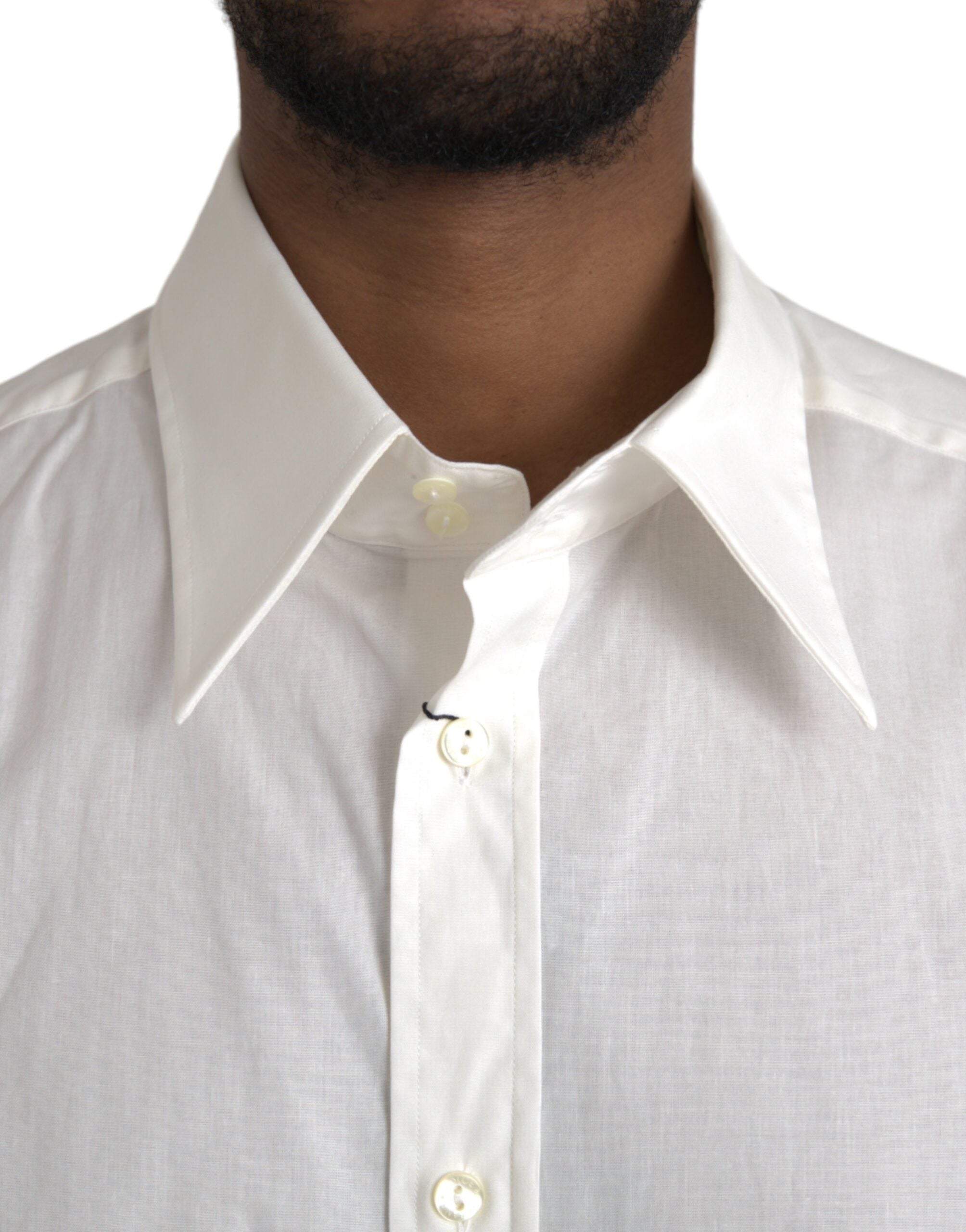 White cotton slim-fit dress shirt by Dolce & Gabbana with gold accents, shown on a hanger.