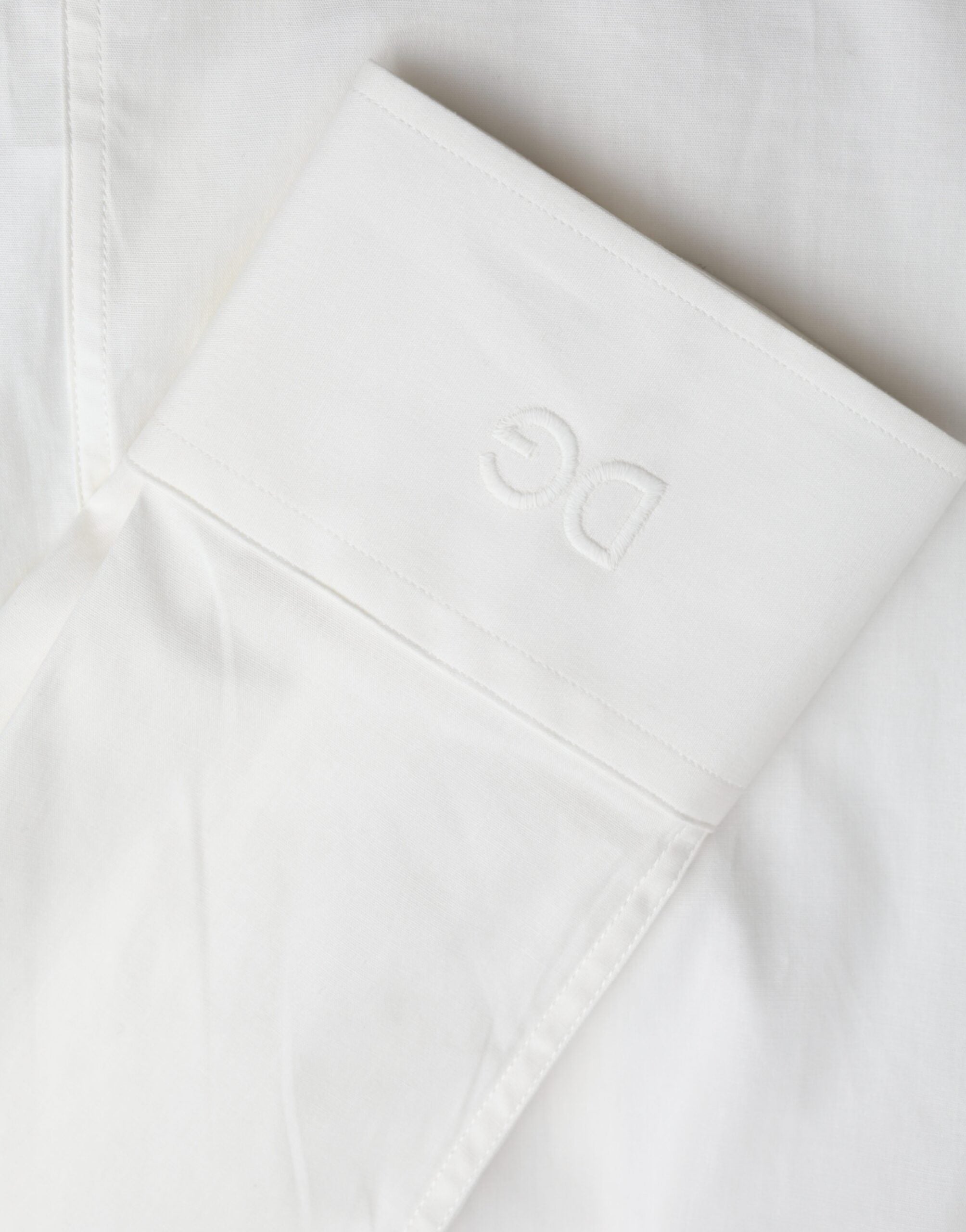 White cotton slim fit dress shirt by Dolce & Gabbana featuring a classic collar and gold accents.
