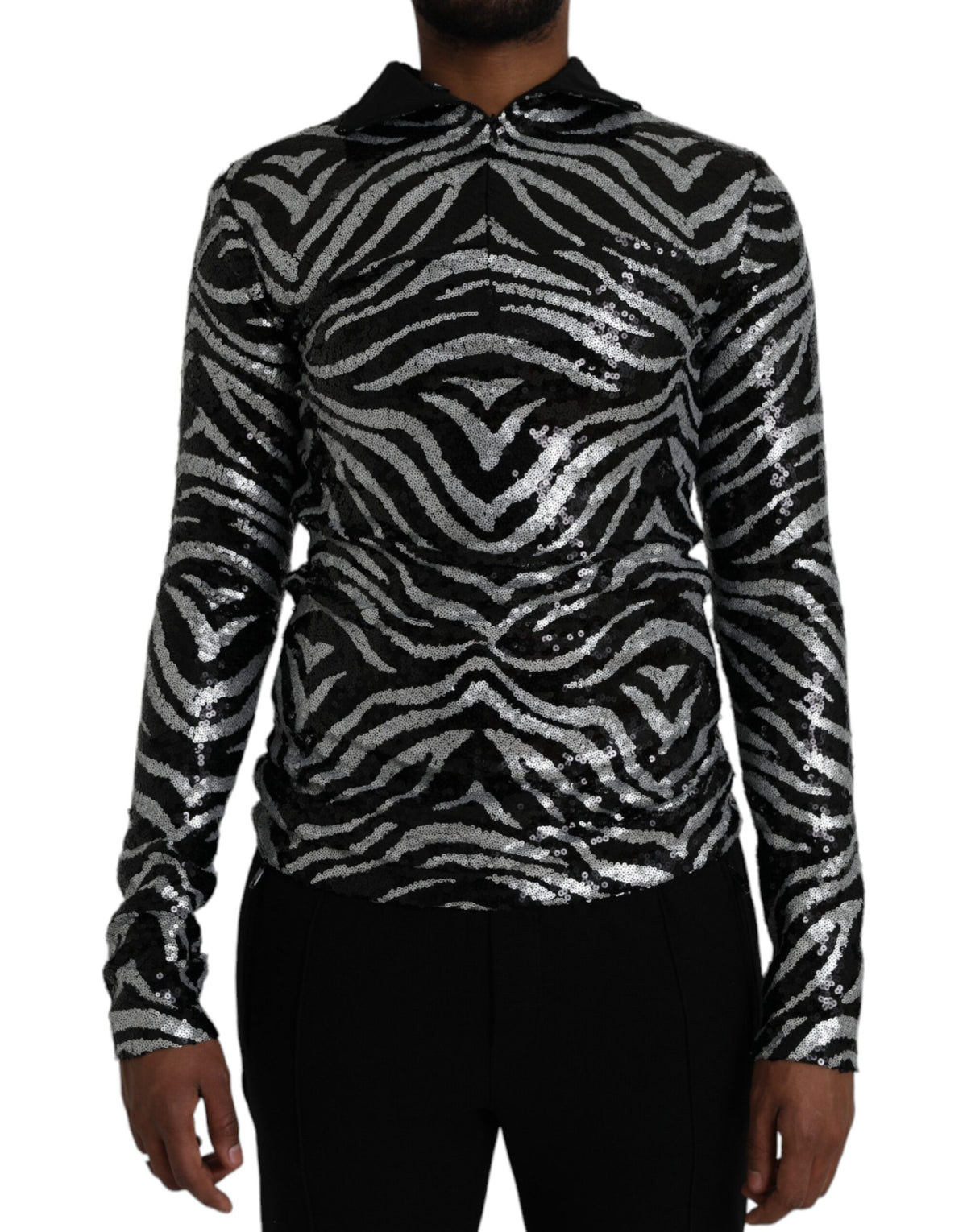Black silver sequined polyester sweater by Dolce & Gabbana showing a close-up of sparkling sequined fabric and sweater neckline.