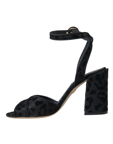 Dolce & Gabbana black leopard suede heels sandals with open toes and ankle straps on a white background.