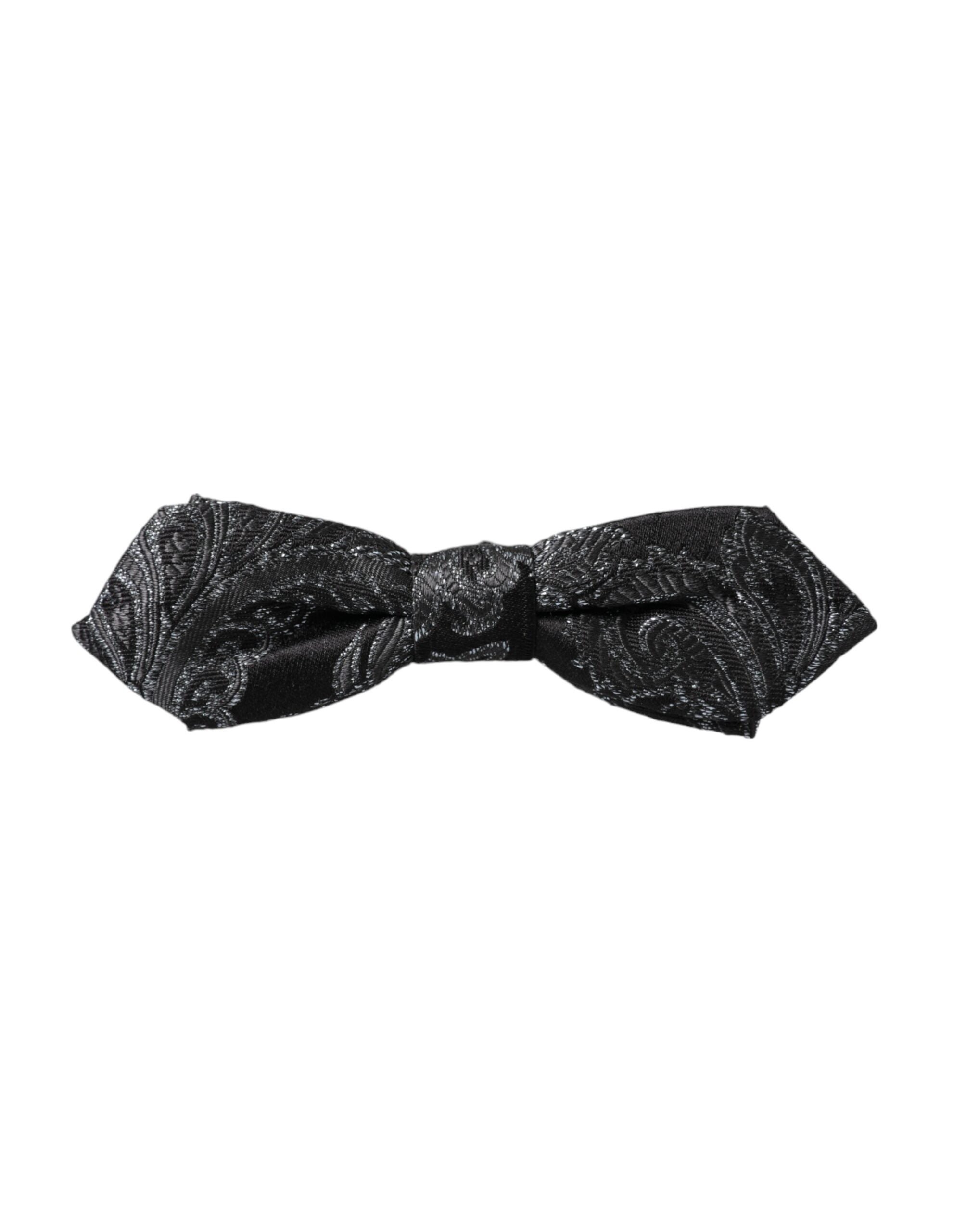 Black silk jacquard men's bow tie with adjustable neck strap by Dolce & Gabbana, featuring intricate woven pattern.