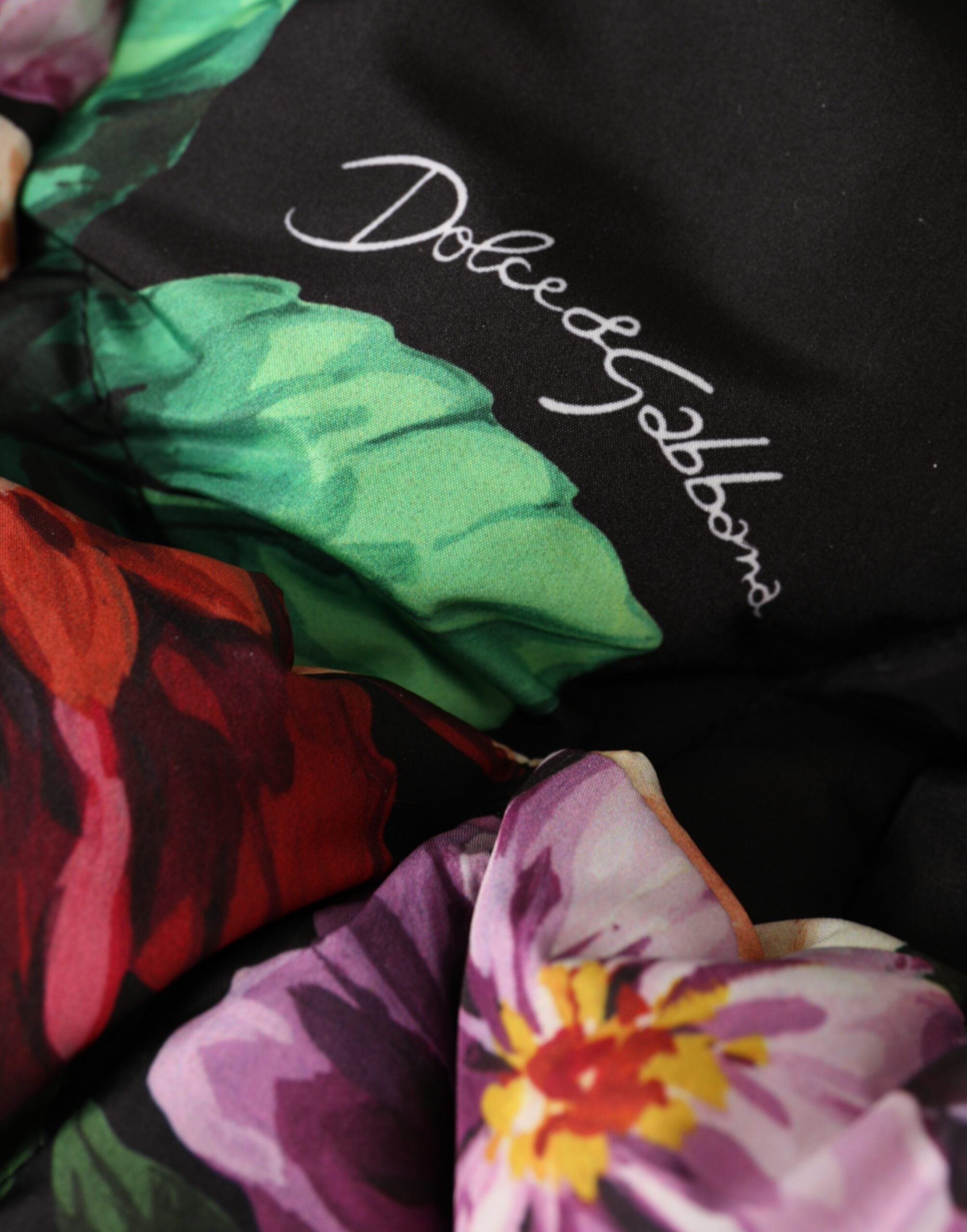 Black floral print whole head wrap hat by Dolce & Gabbana featuring vibrant floral patterns and a stylish, full-head coverage design.