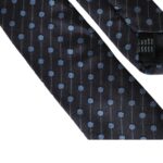 Black and blue polka dot silk adjustable men's tie by Dolce & Gabbana lying flat with visible polka dot pattern.