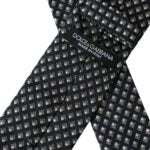 Black silk patterned men's tie by Dolce & Gabbana, featuring an adjustable design and intricate woven pattern.
