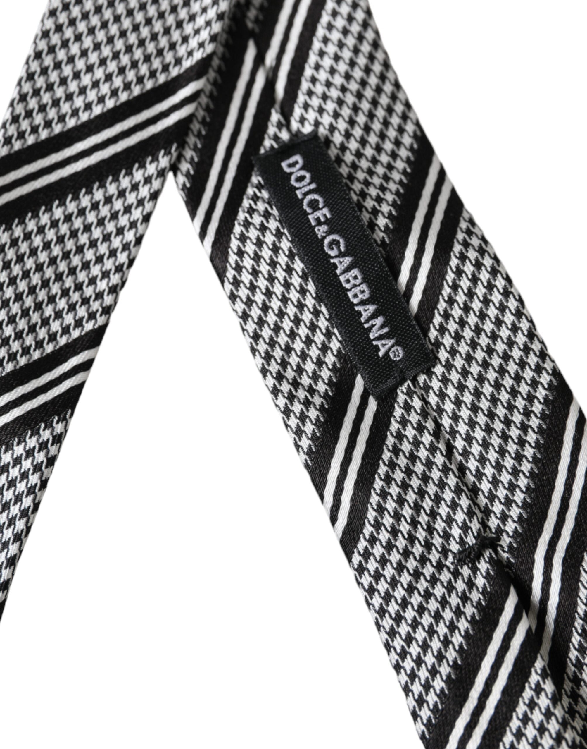 Black and white striped silk adjustable tie by Dolce & Gabbana displayed flat with subtle sheen and classic pattern.