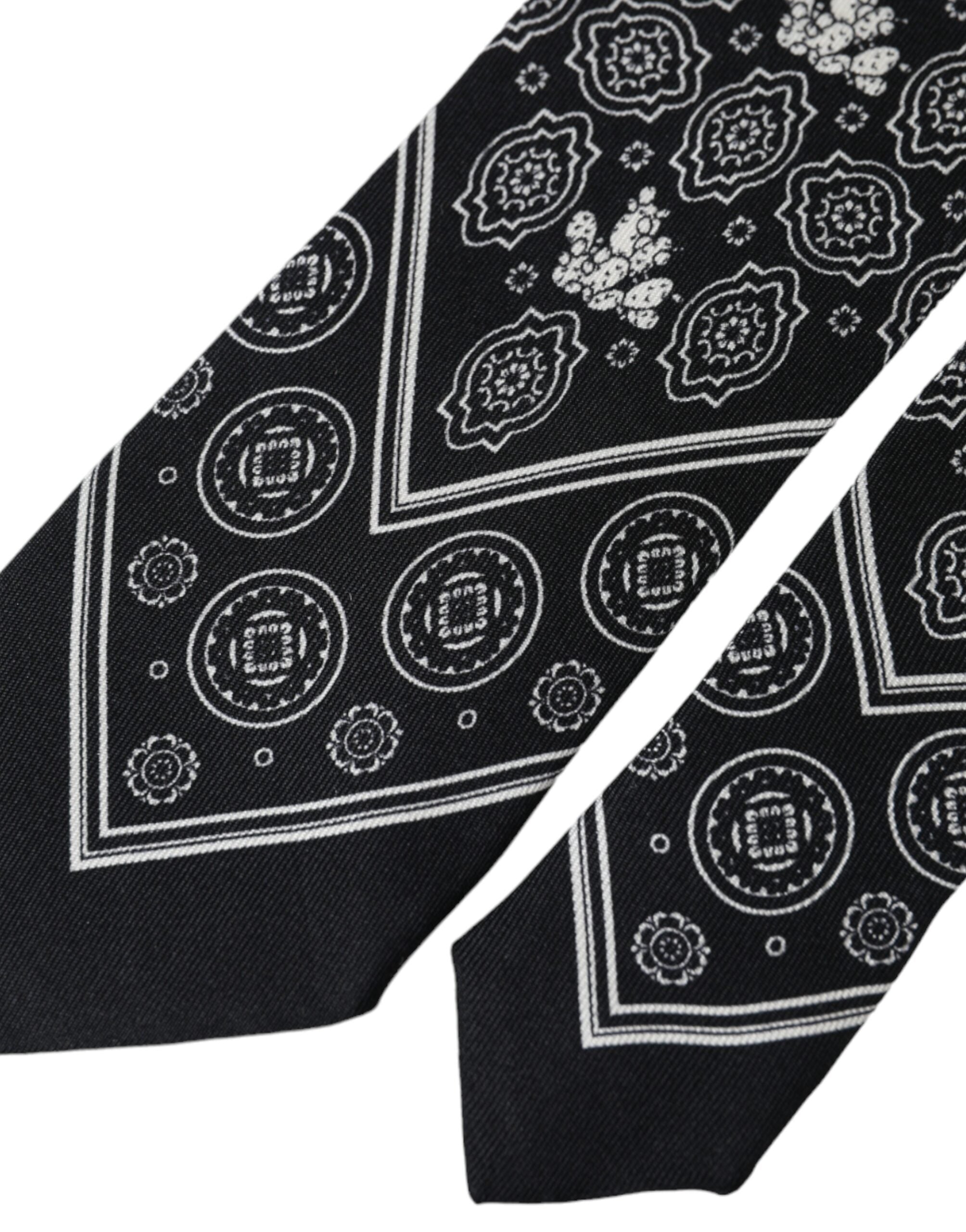 Black patterned 100% silk adjustable tie by Dolce & Gabbana, featuring intricate design and classic knot, ready to complement formal attire.