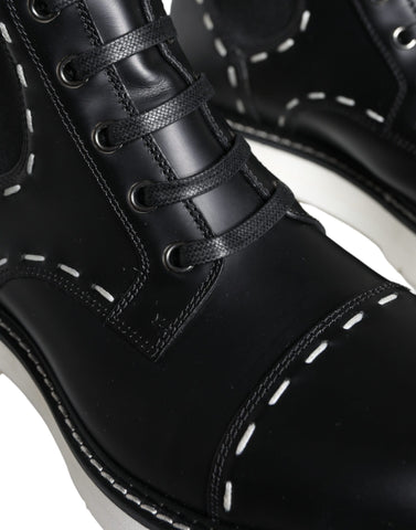 Black leather combat mid-calf boots by Dolce & Gabbana with rugged design and sturdy soles, shown on a plain background