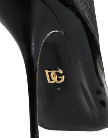 Black leather Dolce & Gabbana stiletto booties with socks, featuring pointed toes and high heels on a plain background.