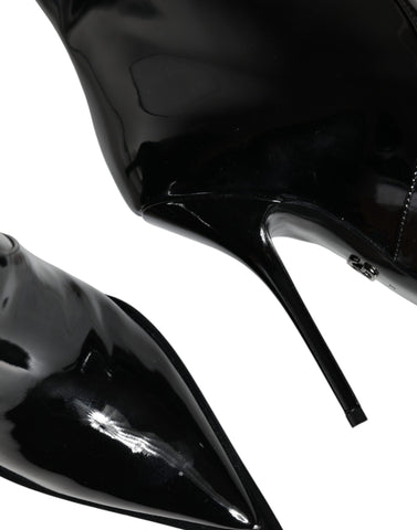 Black patent leather mid calf boots by Dolce & Gabbana, stylish women's shoes with sleek shiny finish and comfortable heel.
