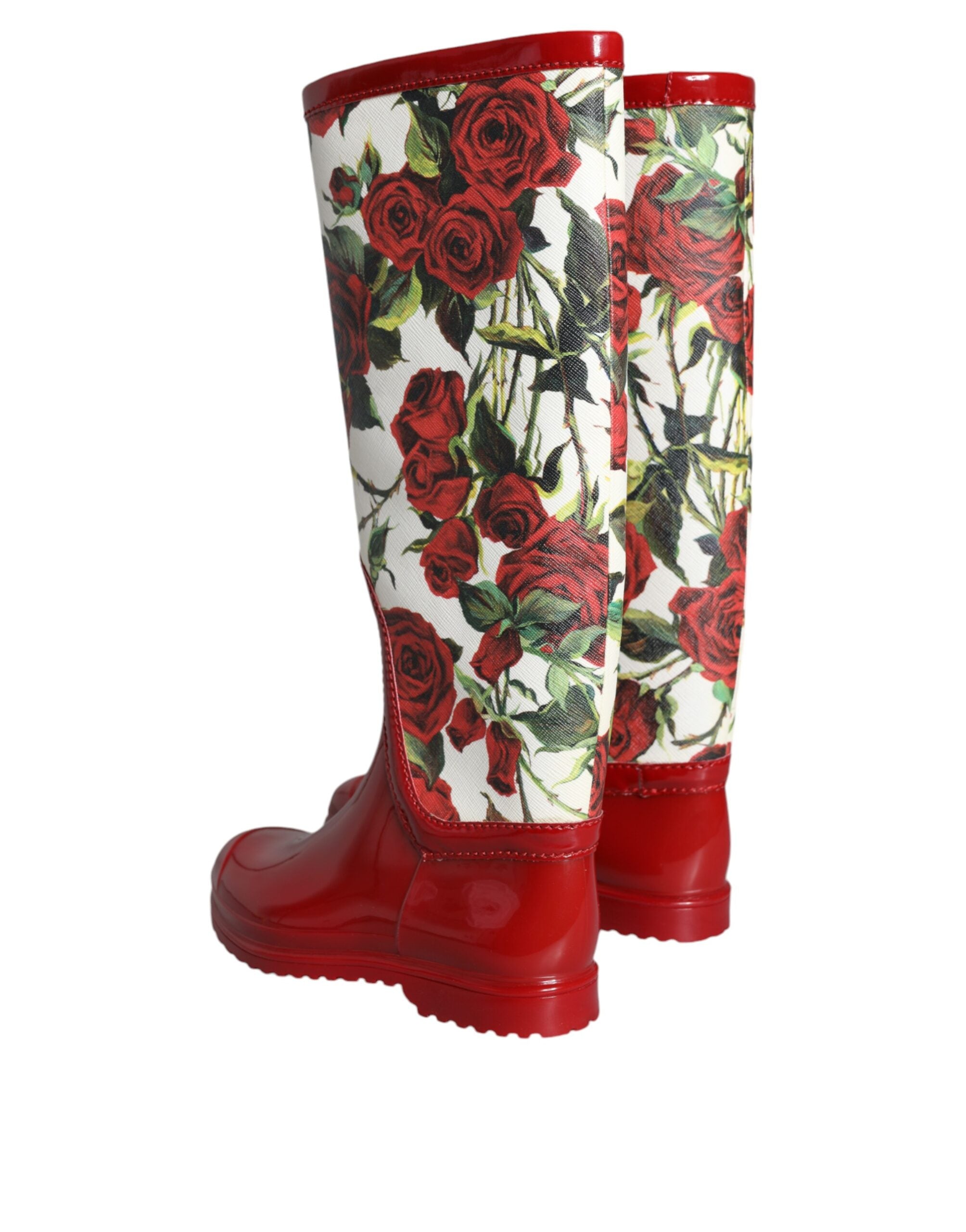 Red floral rubber knee-high flat boots by Dolce & Gabbana, featuring a vibrant floral pattern and a sleek flat sole design.