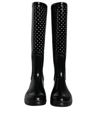 Black polka dot rubber knee-high boots by Dolce & Gabbana, featuring a glossy finish and classic polka dot pattern.