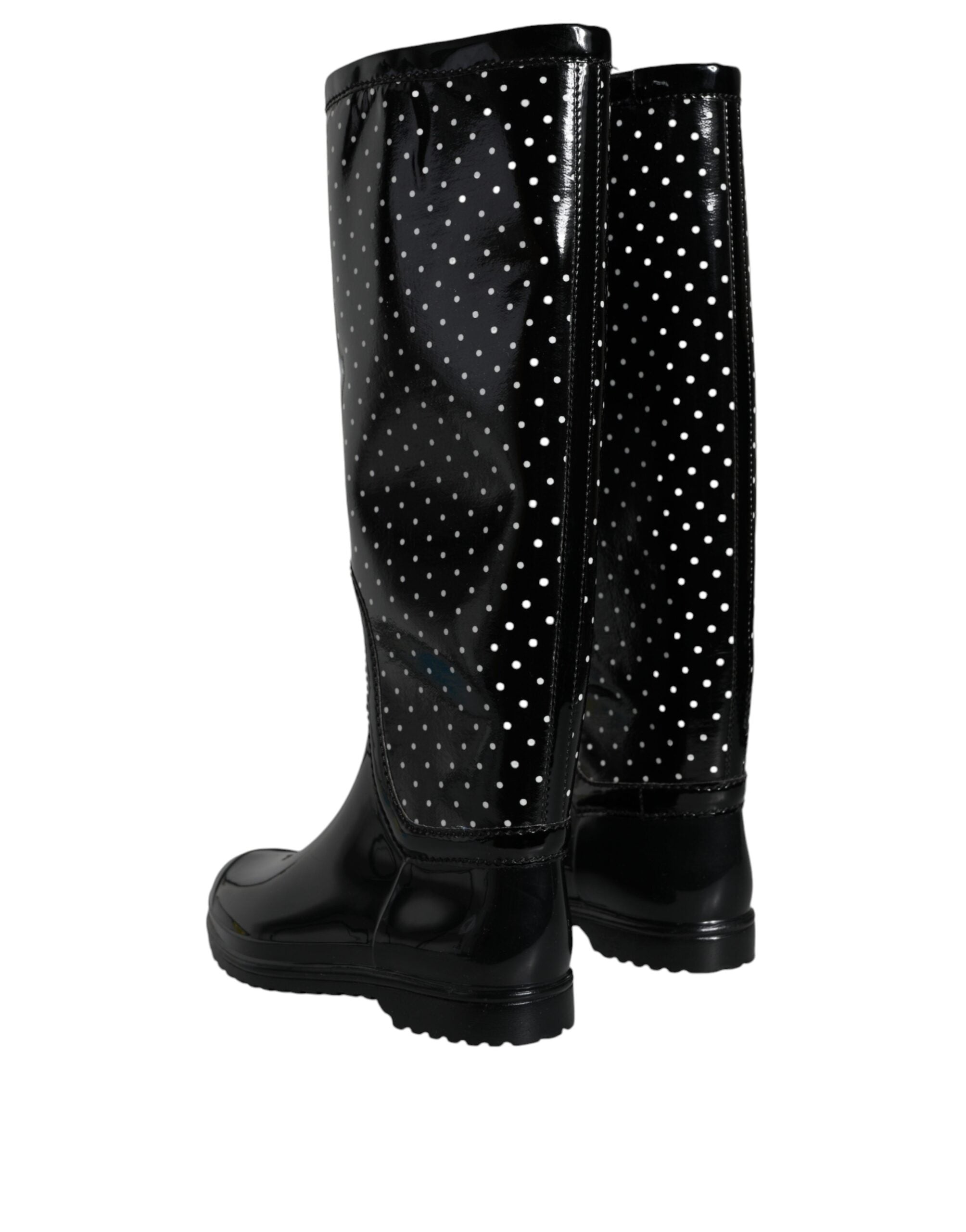 Black polka dot rubber knee-high boots by Dolce & Gabbana with chunky soles and tall shaft, stylish rain footwear.
